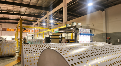 This is our precision gold foil application where our technician carefully oversees equipment applying polka dot patterns onto sturdy paper stock, ensuring flawless alignment and consistent quality for reliable wholesale dinnerware.