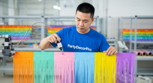 This is our specialized adhesive application process using precision equipment to add strong self-adhesive backing, guaranteeing secure performance and wholesale reliability across all foil fringe curtain orders.