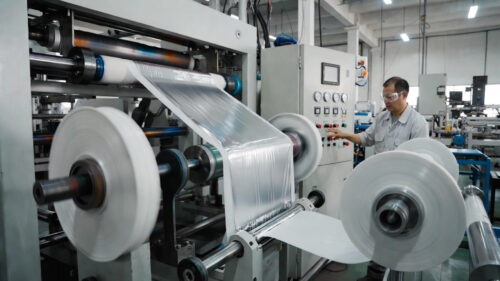 Our skilled workers are operating the precision film lamination line, monitoring and adjusting the equipment via the control panel in real time to ensure perfect bonding between the 23-micron thickened PET base material and the metallic foil layer, producing high-gloss, tear-resistant tinsel curtain raw material.