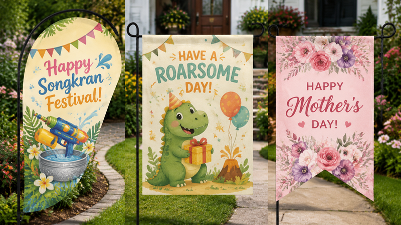 Three decorative garden flags featuring Christmas, Mother’s Day floral and dinosaur party themed outdoor yard flag designs displayed on stands in garden